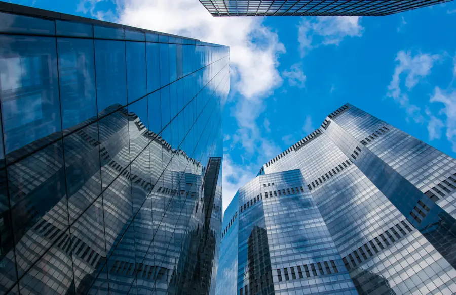Glass office towers rising into a blue sky